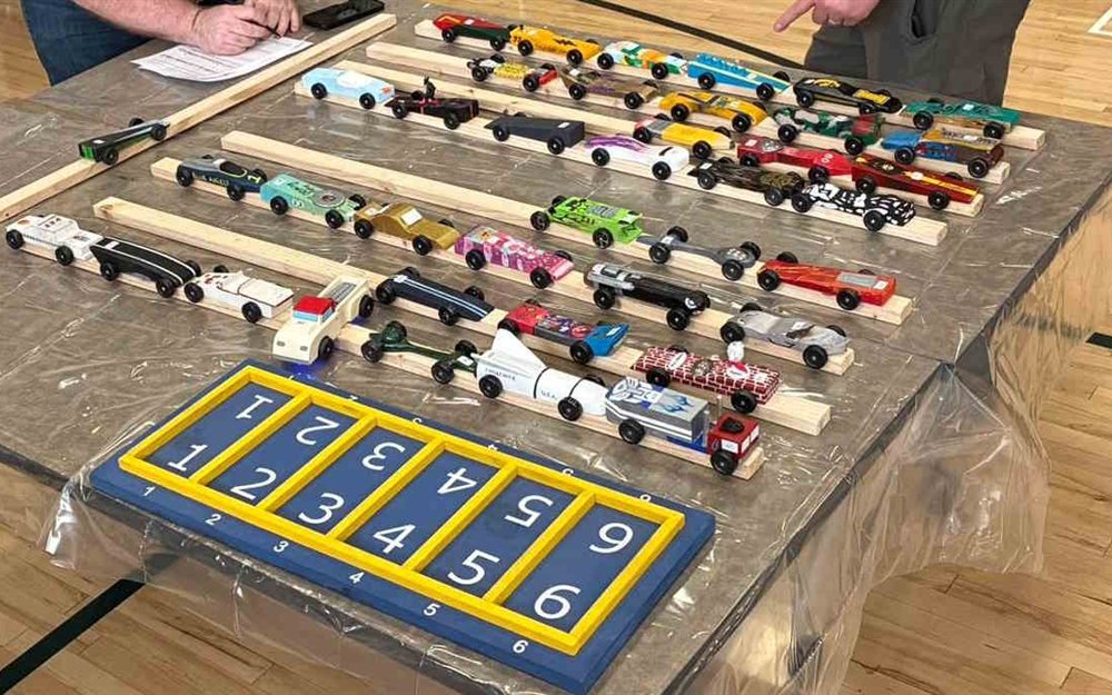 Pinewood Derby cars staged on the track before racing